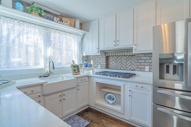 kitchen with backsplash, sink, stainless steel appliances, white cabinets, and dark hardwood / wood-style flooring