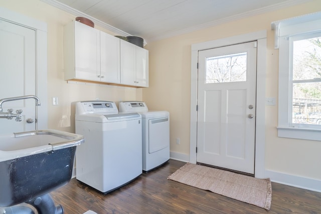 washroom featuring dark hardwood / wood-style floors, crown molding, washing machine and clothes dryer, and cabinets