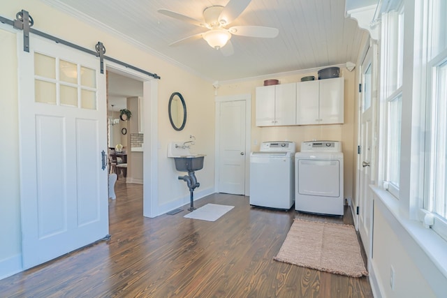 washroom featuring cabinets, washing machine and clothes dryer, ornamental molding, ceiling fan, and a barn door