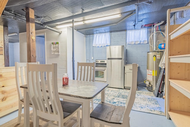 basement featuring water heater and stainless steel refrigerator