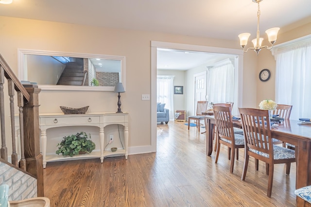 dining area with an inviting chandelier and hardwood / wood-style flooring