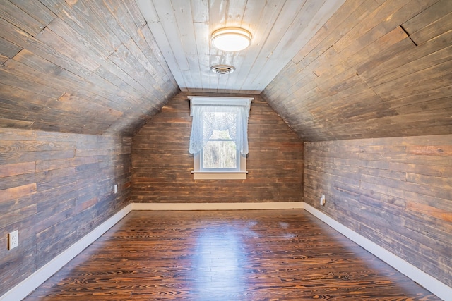 additional living space with lofted ceiling, wood ceiling, dark hardwood / wood-style floors, and wooden walls