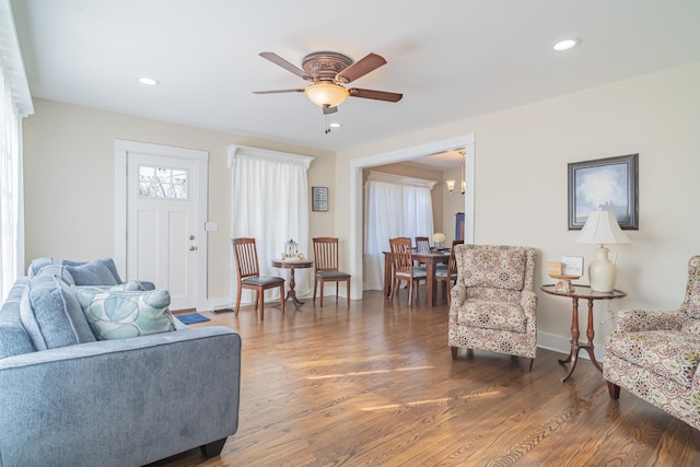 living room with ceiling fan and dark wood-type flooring