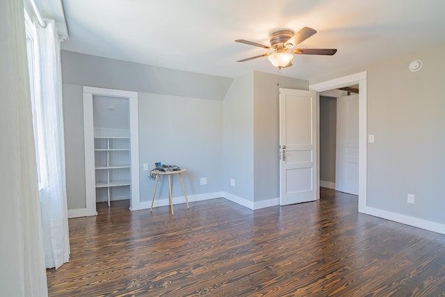 unfurnished room with ceiling fan, vaulted ceiling, and dark wood-type flooring