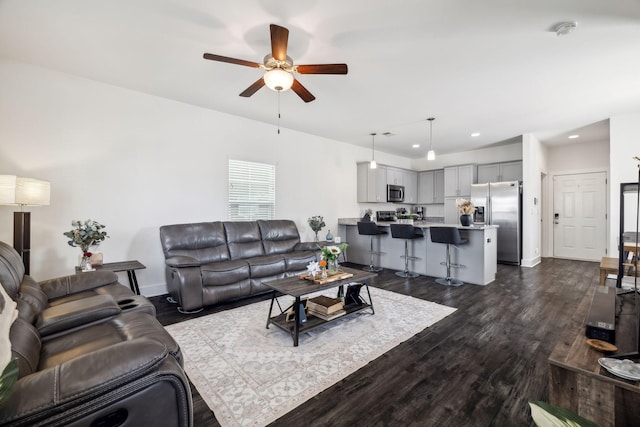 living room with dark hardwood / wood-style flooring and ceiling fan