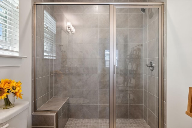 bathroom with toilet and an enclosed shower