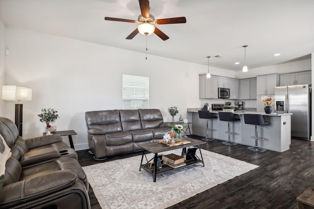 living room featuring ceiling fan and dark hardwood / wood-style floors