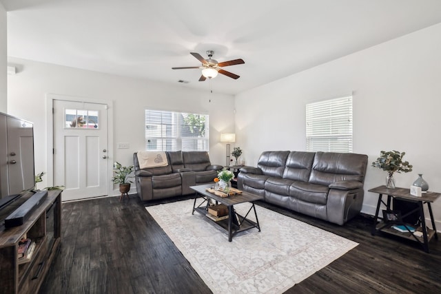 living room featuring dark wood-type flooring and ceiling fan