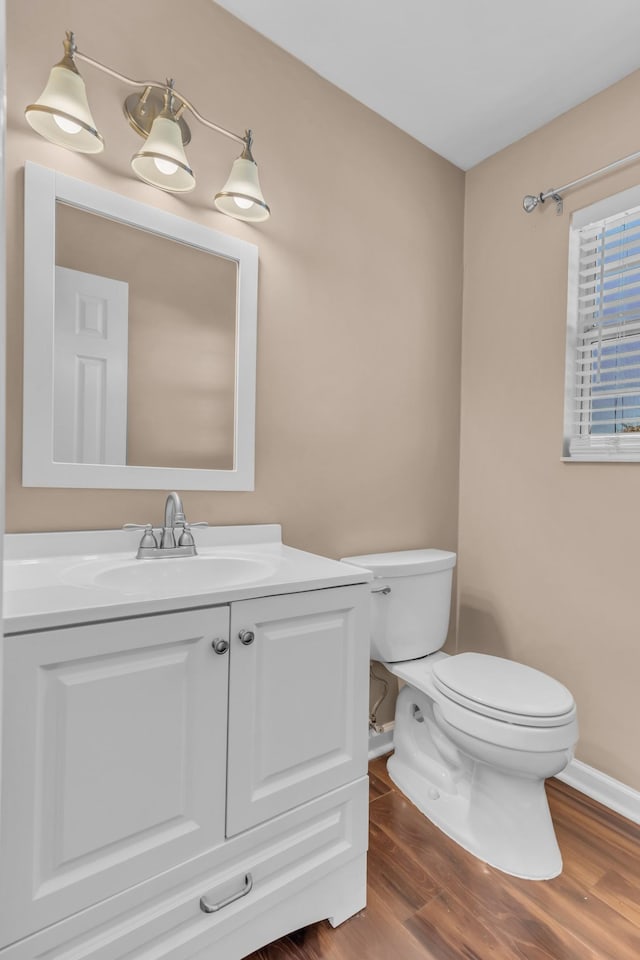 bathroom with toilet, hardwood / wood-style flooring, and vanity