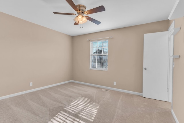 spare room featuring light carpet and ceiling fan