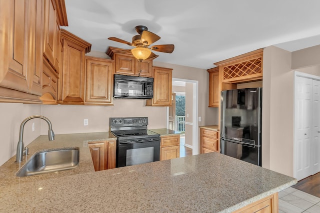 kitchen with sink, ceiling fan, kitchen peninsula, light stone countertops, and black appliances