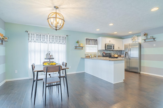 dining space with sink, a notable chandelier, dark hardwood / wood-style floors, and a textured ceiling