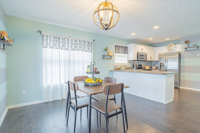 dining space with a textured ceiling, dark hardwood / wood-style flooring, and a chandelier