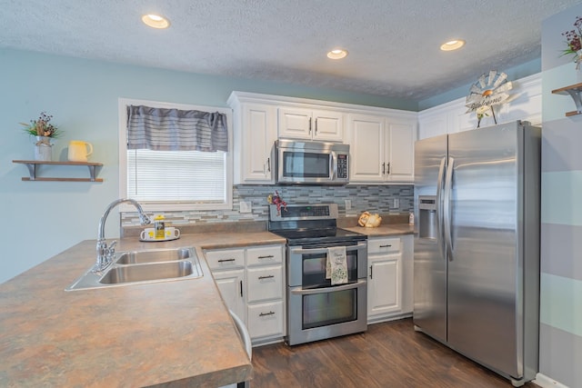 kitchen featuring white cabinets, appliances with stainless steel finishes, a textured ceiling, and sink