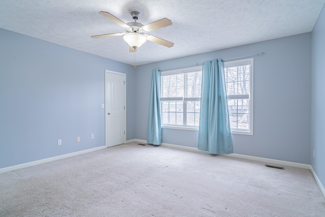 carpeted spare room with ceiling fan and a textured ceiling