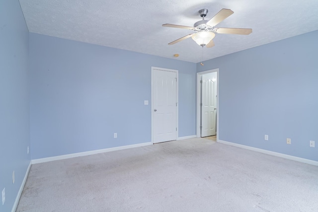 carpeted empty room featuring ceiling fan and a textured ceiling