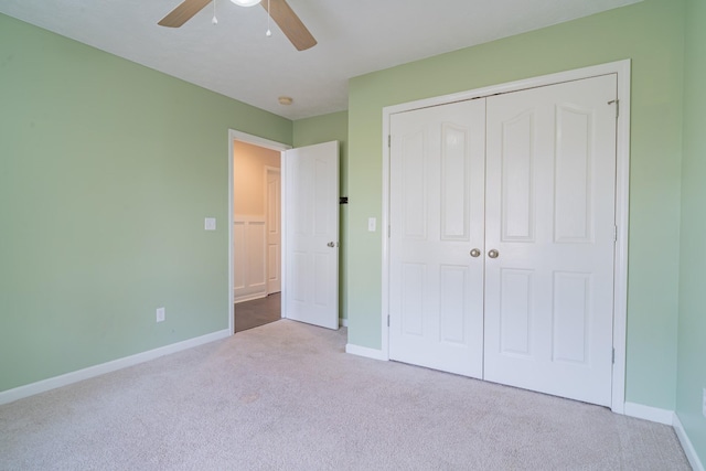 unfurnished bedroom with light colored carpet, a closet, and ceiling fan