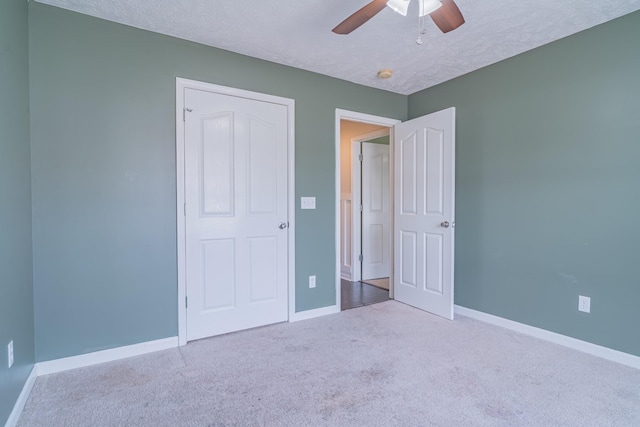 unfurnished bedroom featuring ceiling fan, a textured ceiling, and light carpet