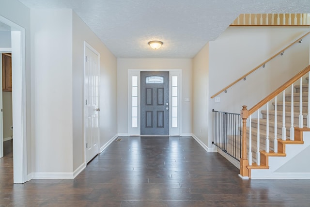 foyer entrance featuring a textured ceiling and dark hardwood / wood-style floors