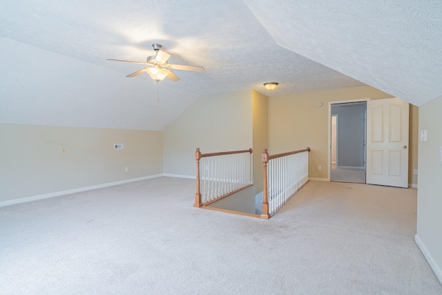 bonus room with ceiling fan, a textured ceiling, light carpet, and vaulted ceiling