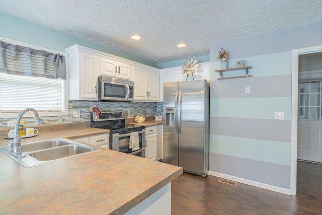 kitchen featuring sink, white cabinetry, a textured ceiling, and stainless steel appliances