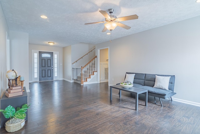 living room featuring ceiling fan, a textured ceiling, and dark hardwood / wood-style flooring