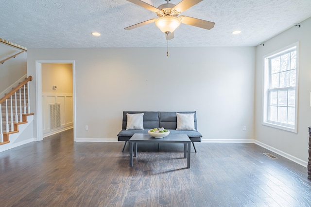 sitting room with ceiling fan, dark hardwood / wood-style floors, and a textured ceiling