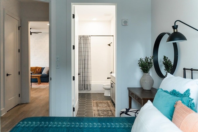 bedroom featuring ensuite bath and dark hardwood / wood-style flooring