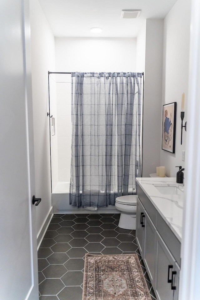 full bathroom with tile patterned flooring, shower / tub combo with curtain, vanity, and toilet