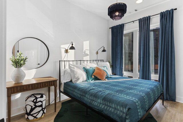 bedroom with wood finished floors and visible vents