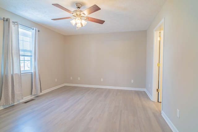 unfurnished room featuring a textured ceiling, light wood-type flooring, and ceiling fan