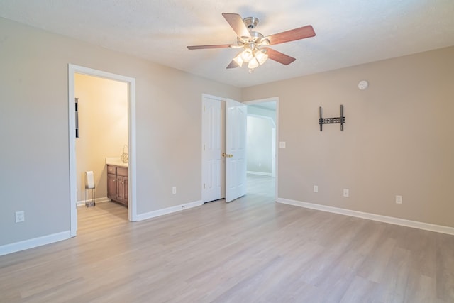 interior space featuring ensuite bathroom, a textured ceiling, ceiling fan, and light hardwood / wood-style flooring