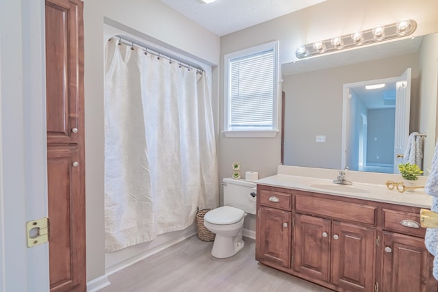 full bathroom featuring shower / tub combo, wood-type flooring, toilet, vanity, and a textured ceiling