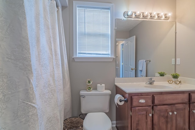 bathroom featuring toilet, vanity, and plenty of natural light