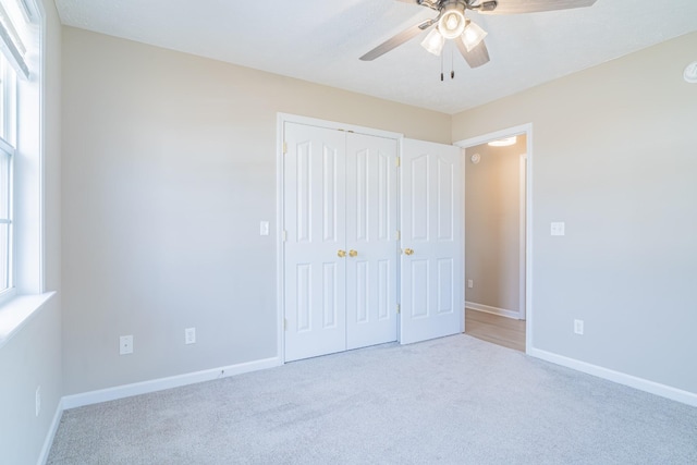 unfurnished bedroom with a closet, light carpet, and ceiling fan