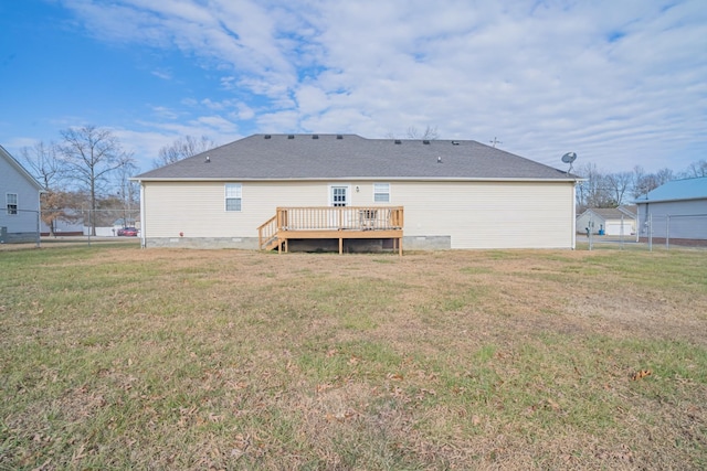 rear view of house featuring a lawn and a wooden deck