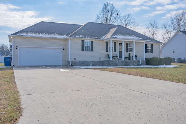 single story home with a front yard, a garage, a porch, and central air condition unit