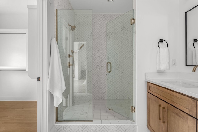 bathroom featuring walk in shower, vanity, and hardwood / wood-style flooring