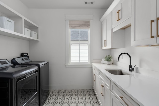 clothes washing area with sink, cabinets, independent washer and dryer, and light tile patterned floors