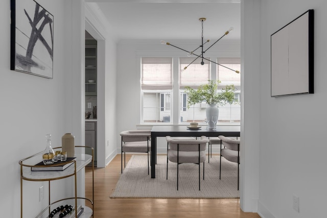 dining space featuring light wood-type flooring and a notable chandelier