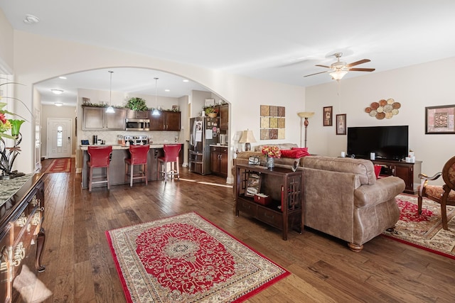 living room with dark wood-type flooring and ceiling fan