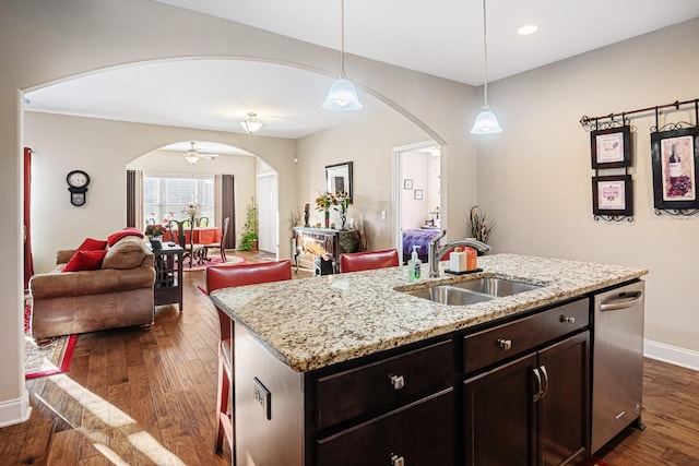 kitchen with sink, ceiling fan, pendant lighting, and an island with sink