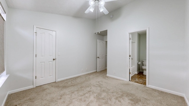 unfurnished bedroom with a closet, ensuite bathroom, ceiling fan, and light carpet