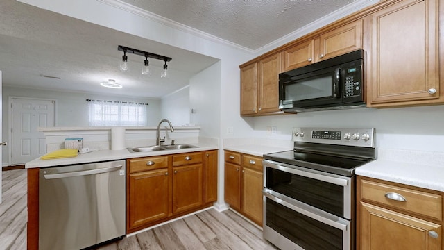 kitchen featuring stainless steel appliances, sink, a textured ceiling, ornamental molding, and kitchen peninsula