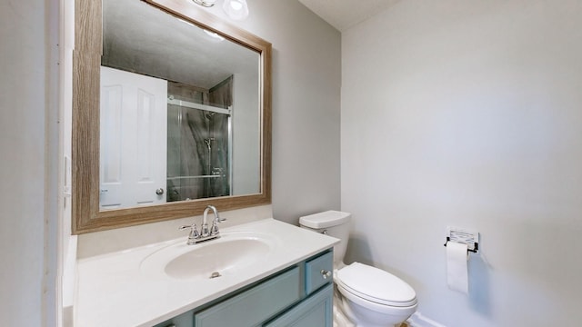 bathroom featuring toilet, a shower with door, and vanity