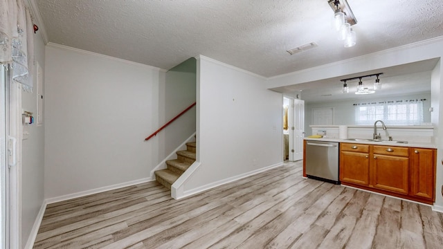 kitchen with light wood-type flooring, dishwasher, a textured ceiling, and sink