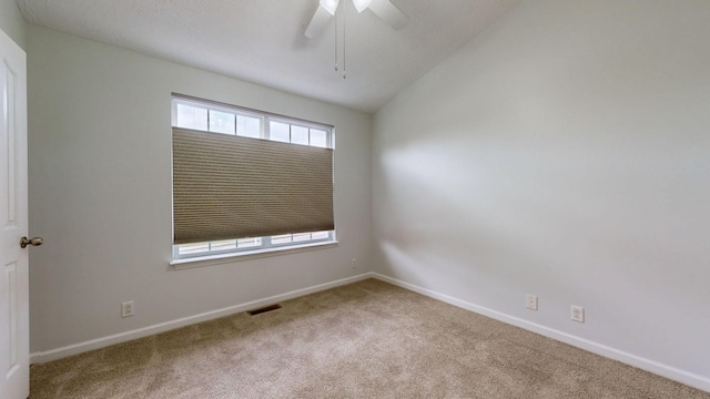 carpeted spare room with lofted ceiling and ceiling fan