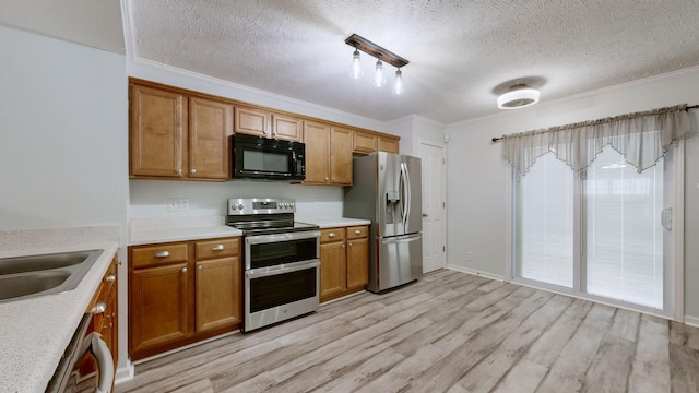 kitchen featuring stainless steel appliances, sink, a textured ceiling, light hardwood / wood-style flooring, and crown molding