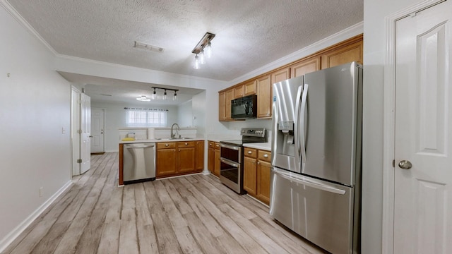 kitchen featuring stainless steel appliances, sink, ornamental molding, light hardwood / wood-style flooring, and kitchen peninsula