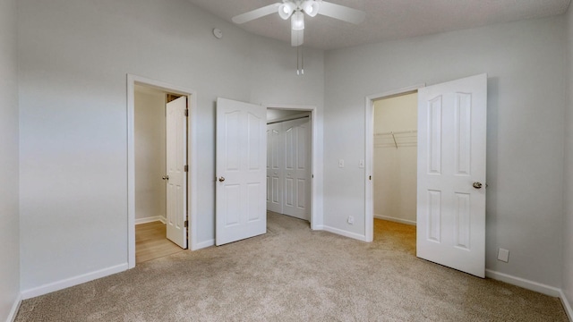 unfurnished bedroom with ceiling fan, light colored carpet, and a spacious closet